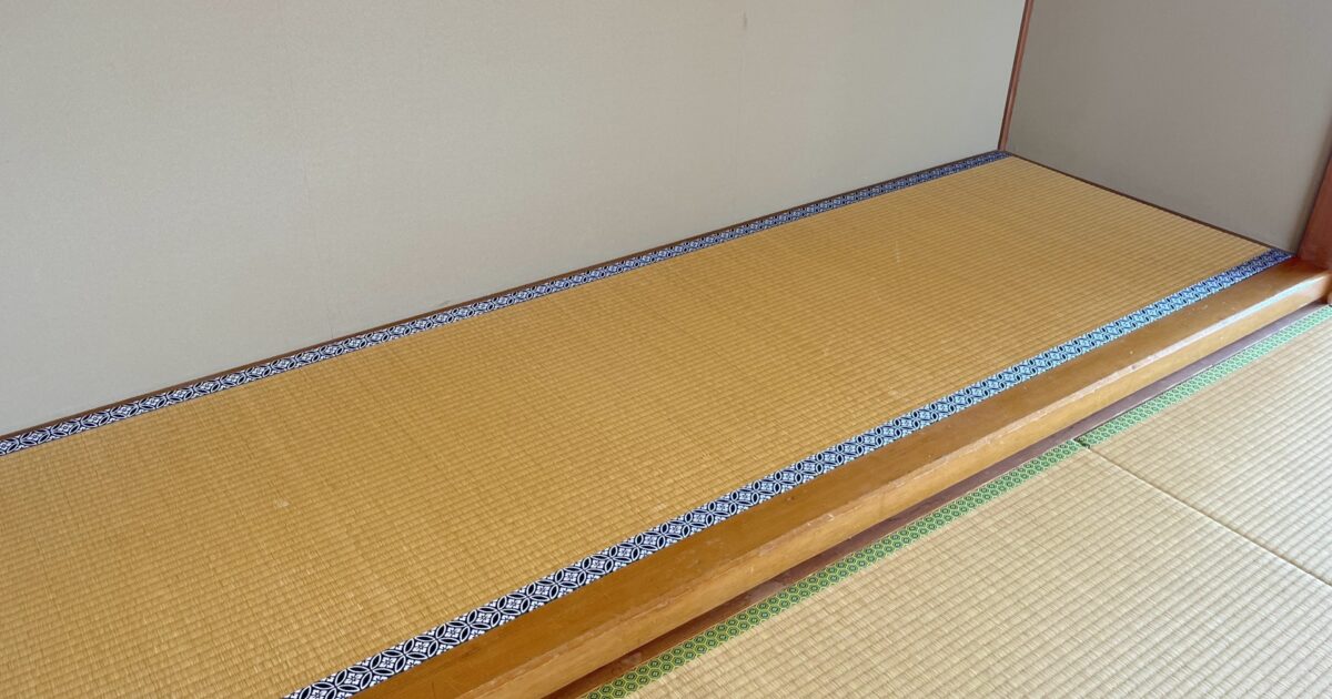 青い縁の畳が敷かれた床の間のある和室